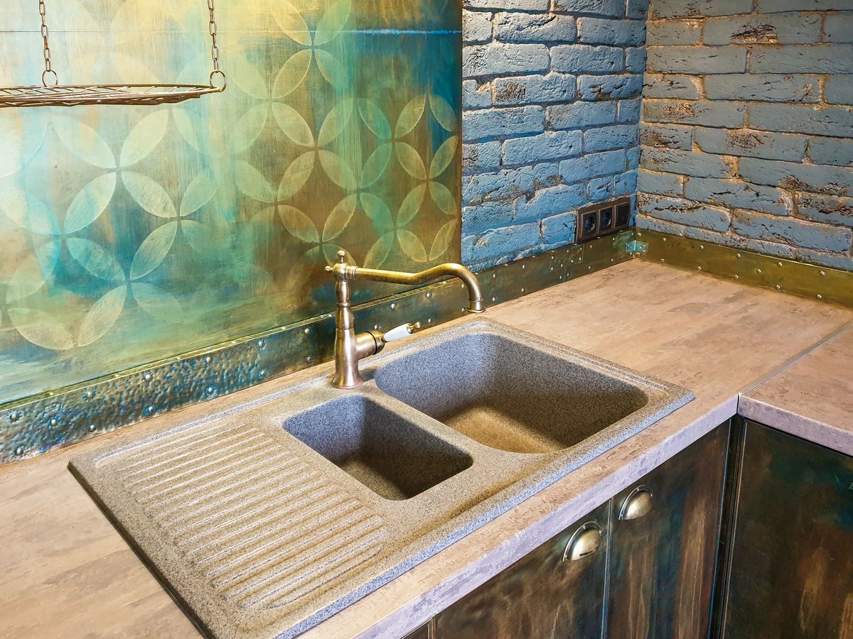 A double kitchen sink with a bronze faucet
